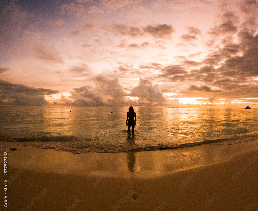 woman on a tropical beach at sunset