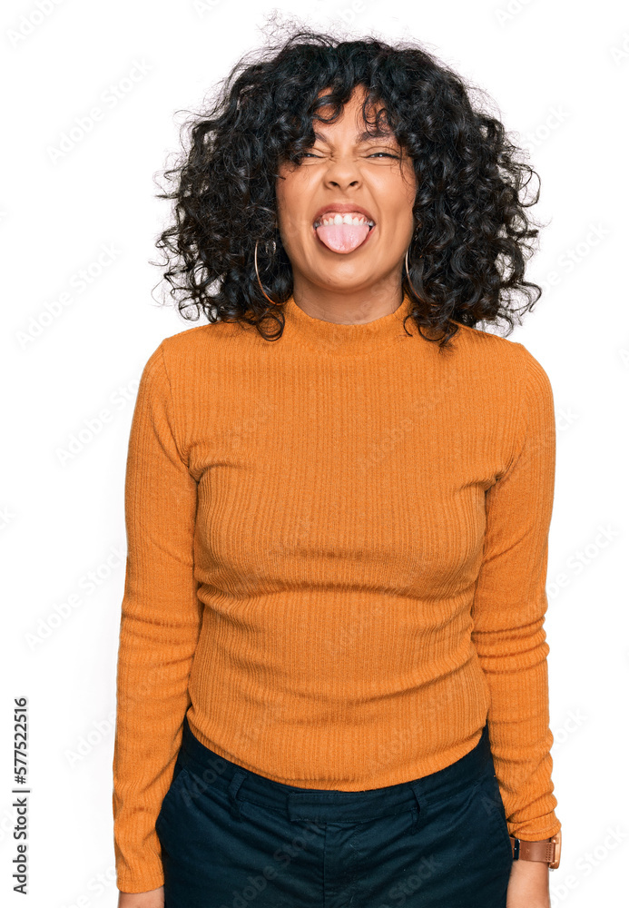 Young hispanic woman wearing casual clothes sticking tongue out happy with funny expression. emotion concept. Young hispanic woman wearing casual clothes sticking tongue out happy with funny expression. emotion concept.