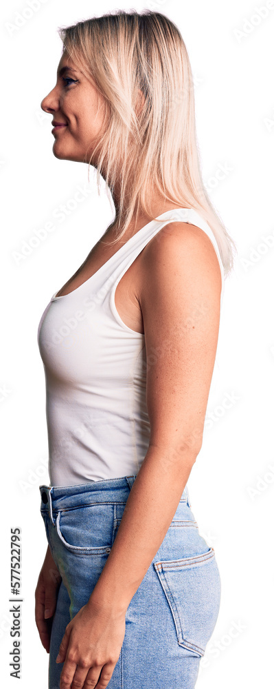 Young beautiful blonde woman wearing casual sleeveless t-shirt looking to side, relax profile pose with natural face with confident smile. Young beautiful blonde woman wearing casual sleeveless t-shirt looking to side, relax profile pose with natural face with confident smile.