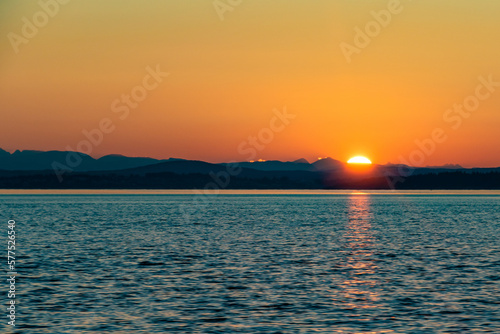 Sun Setting Over Horizon and Mountains Along Coast of Strait of Georgia in Vancouver Island   British Columbia  Canada