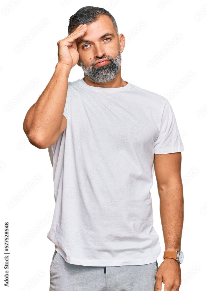 Middle age handsome man wearing casual white tshirt worried and stressed about a problem with hand on forehead, nervous and anxious for crisis Middle age handsome man wearing casual white tshirt worried and stressed about a problem with hand on forehead, nervous and anxious for crisis