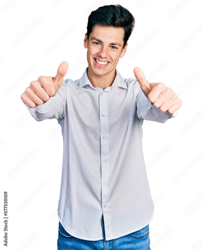 Young hispanic business man wearing business clothes approving doing positive gesture with hand, thumbs up smiling and happy for success. winner gesture. Young hispanic business man wearing business clothes approving doing positive gesture with hand, thumbs up smiling and happy for success. winner gesture.