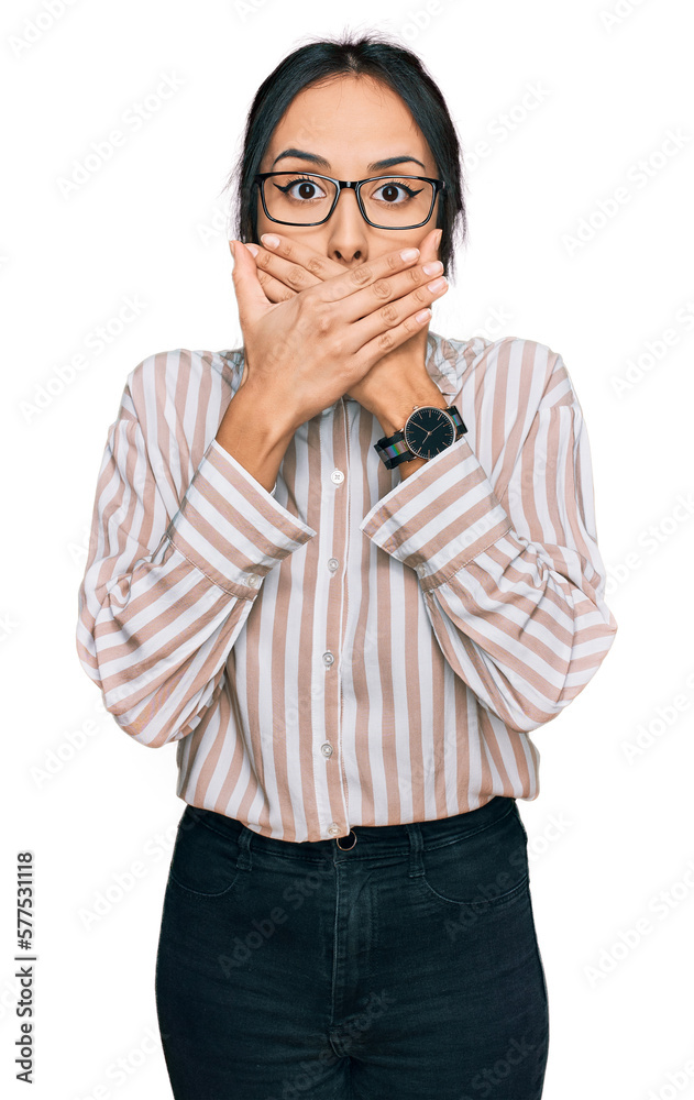 Young hispanic girl wearing casual clothes and glasses shocked covering mouth with hands for mistake. secret concept. Young hispanic girl wearing casual clothes and glasses shocked covering mouth with hands for mistake. secret concept.
