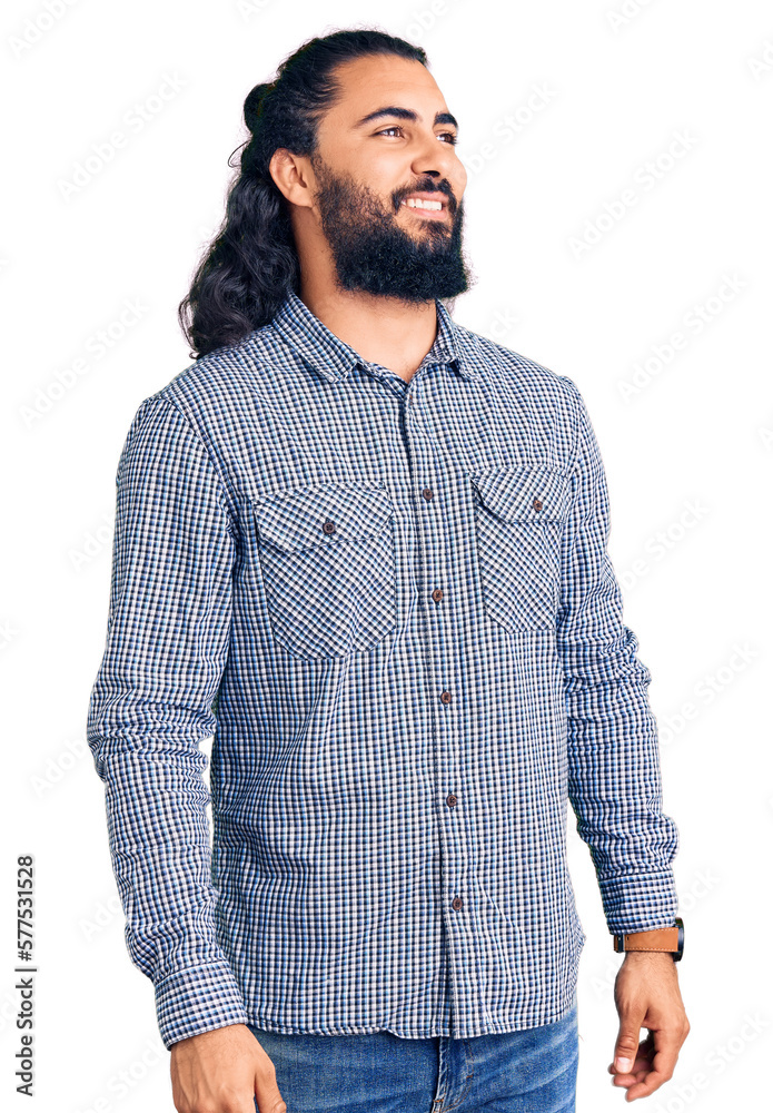 Young arab man wearing casual clothes looking away to side with smile on face, natural expression. laughing confident. Young arab man wearing casual clothes looking away to side with smile on face, natural expression. laughing confident.