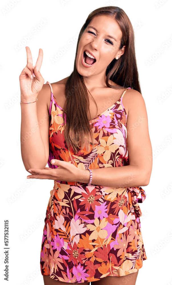 Young beautiful hispanic woman wearing casual clothes smiling with happy face winking at the camera doing victory sign with fingers. number two. Young beautiful hispanic woman wearing casual clothes smiling with happy face winking at the camera doing victory sign with fingers. number two.
