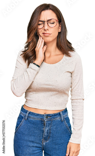 Young brunette woman wearing casual clothes and glasses touching mouth with hand with painful expression because of toothache or dental illness on teeth. dentist © Krakenimages.com