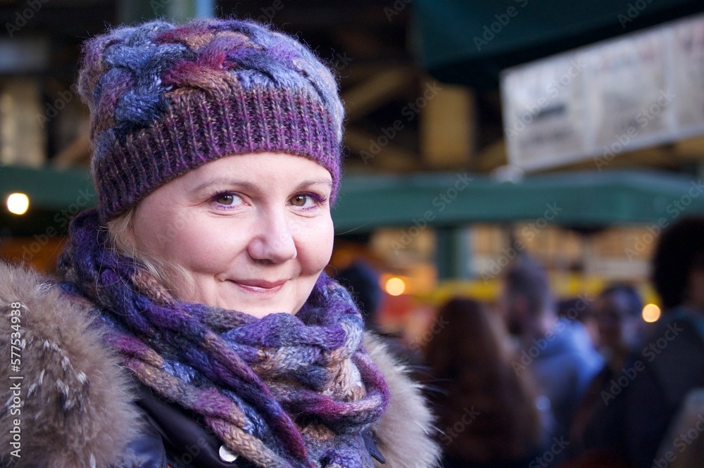 young woman smiling at the camera with market blurred in the background, portrait of a person young woman smiling at the camera with market blurred in the background, portrait of a person