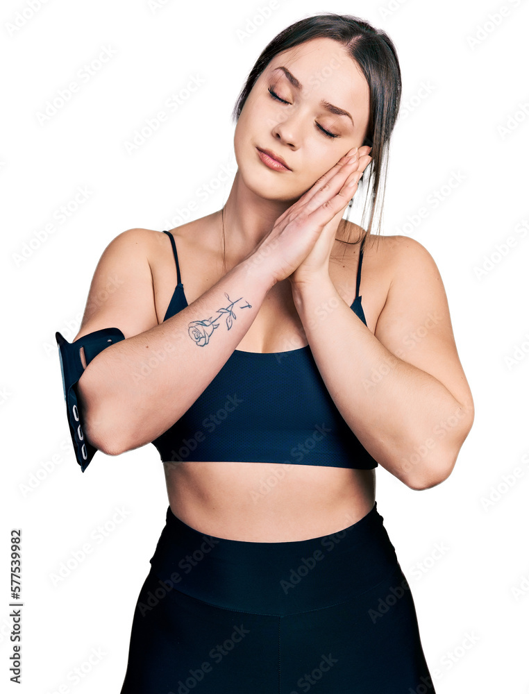 Young hispanic woman wearing sportswear sleeping tired dreaming and posing with hands together while smiling with closed eyes. Young hispanic woman wearing sportswear sleeping tired dreaming and posing with hands together while smiling with closed eyes.