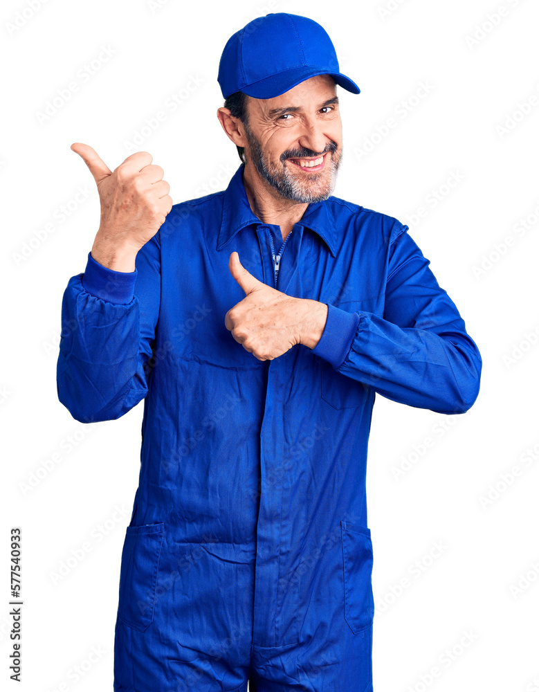 Middle age handsome man wearing mechanic uniform pointing to the back behind with hand and thumbs up, smiling confident Middle age handsome man wearing mechanic uniform pointing to the back behind with hand and thumbs up, smiling confident