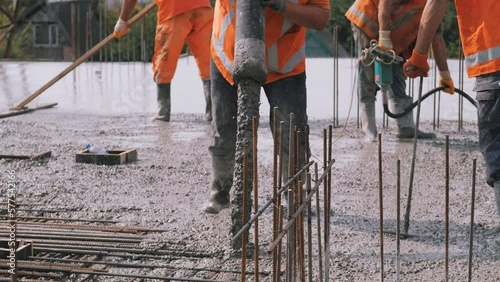 Concrete mixture formwork, worker pouring on a building construction site. photo