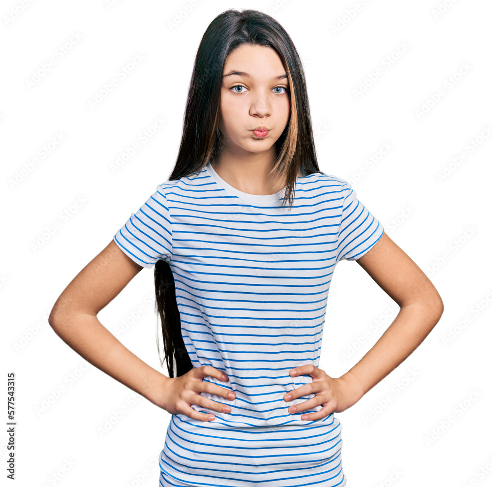 Young brunette girl with long hair with arms akimbo puffing cheeks with funny face. mouth inflated with air, catching air. Young brunette girl with long hair with arms akimbo puffing cheeks with funny face. mouth inflated with air, catching air.