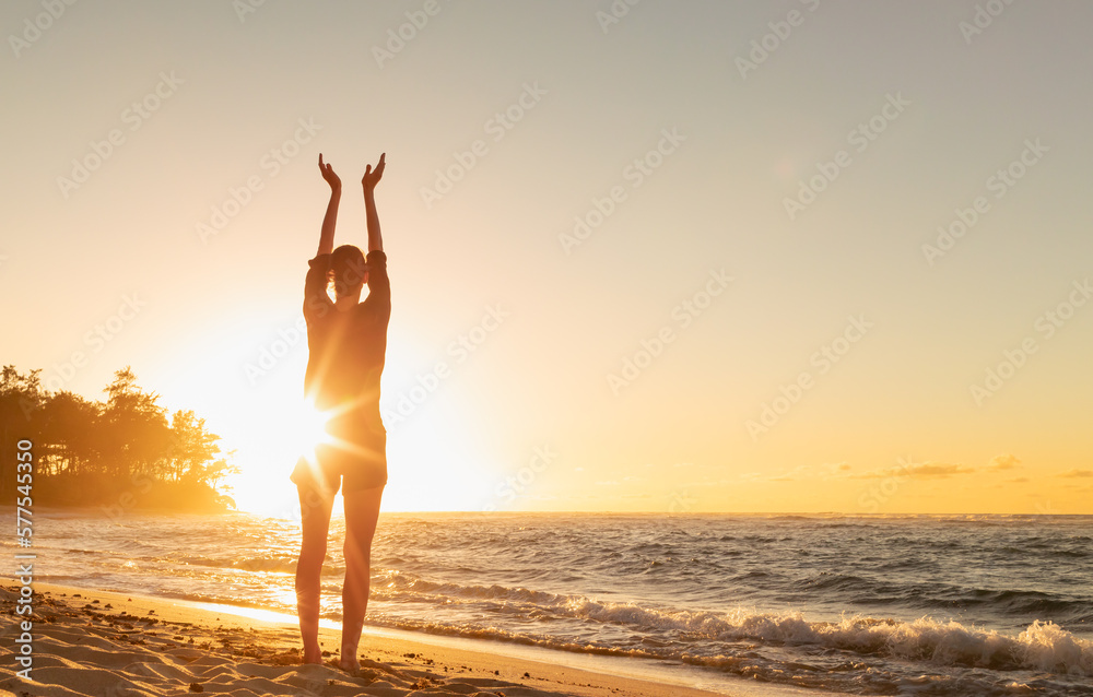 Female feeling the the energy and warmth of the sun  on the beach at sunset - obrazy, fototapety, plakaty 