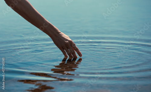 hands touching calm water making ripples 
