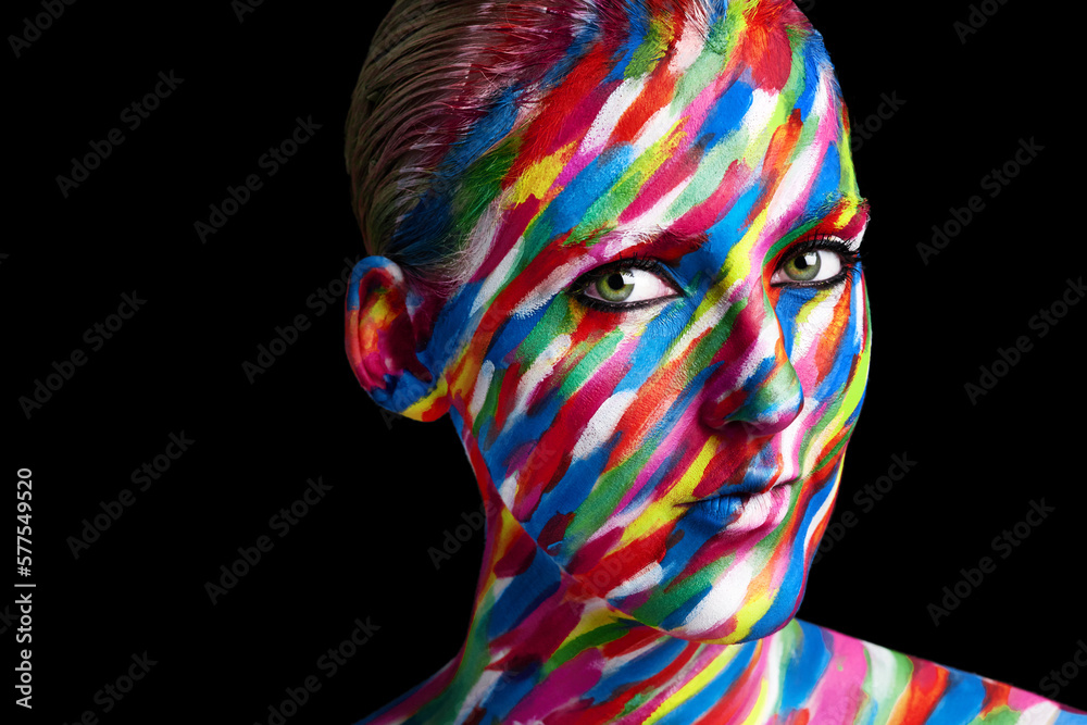 Getting creative with colors. Studio shot of a young woman posing with brightly colored paint on her face against a black background. Getting creative with colors. Studio shot of a young woman posing with brightly colored paint on her face against a black background.