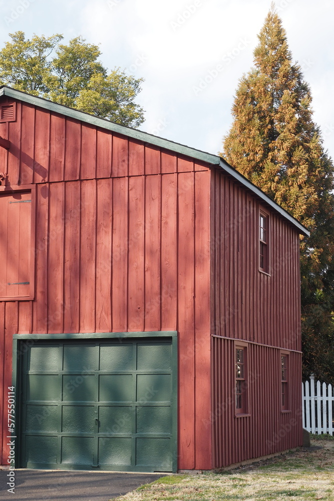 The red barn has green garage doors. The red barn has green garage doors.