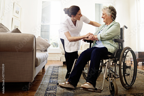 The best care you could hope for. Shot of a smiling caregiver helping a senior woman in a wheelchair at home.