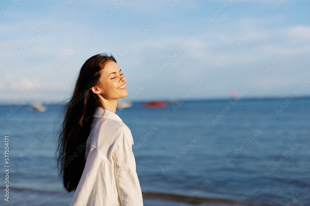 Woman smile freedom on vacation walking on the beach by the ocean in Bali sunset, happy travel and vacation, sunset light Woman smile freedom on vacation walking on the beach by the ocean in Bali sunset, happy travel and vacation, sunset light