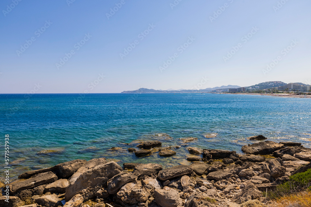 Beautiful view of stone coast of Mediterranean Sea with hotels on horizon. Greece. Beautiful view of stone coast of Mediterranean Sea with hotels on horizon. Greece.