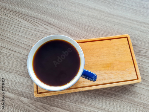 black coffee on wooden saucer and wooden table in cafe