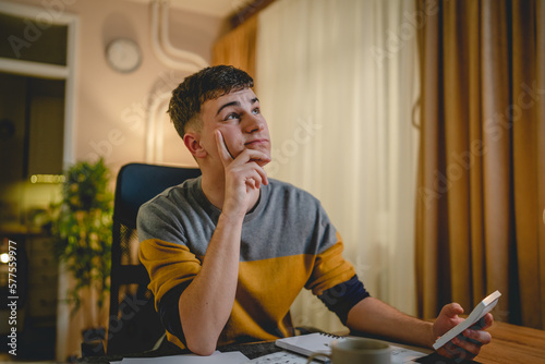 Young caucasian man teenager student study at home at the table night