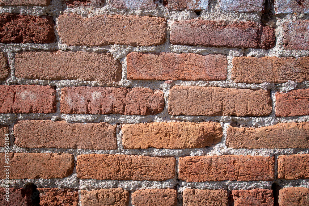 An old brick wall showing a weathered history which can be used as a background An old brick wall showing a weathered history which can be used as a background