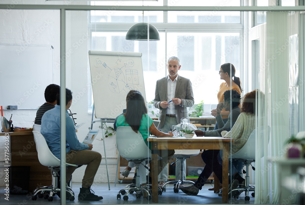 He has their full attention. Shot of a group of coworkers in a boardroom meeting.