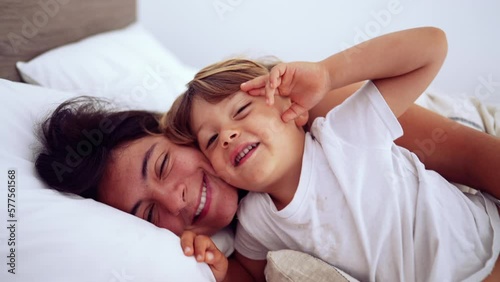 Wallpaper Mural Lifestyle moment of mother and child lying in bed looking at camera smiling. Motherhood happiness concept Torontodigital.ca