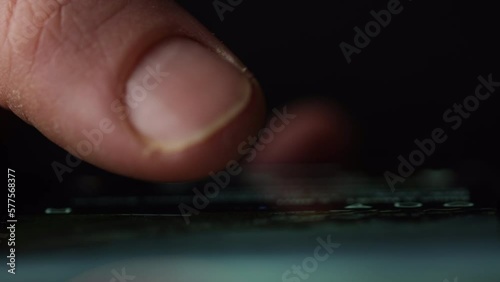 Macro shot of a finger doom scrolling social media or browsing internet. Front view with reflection on glass