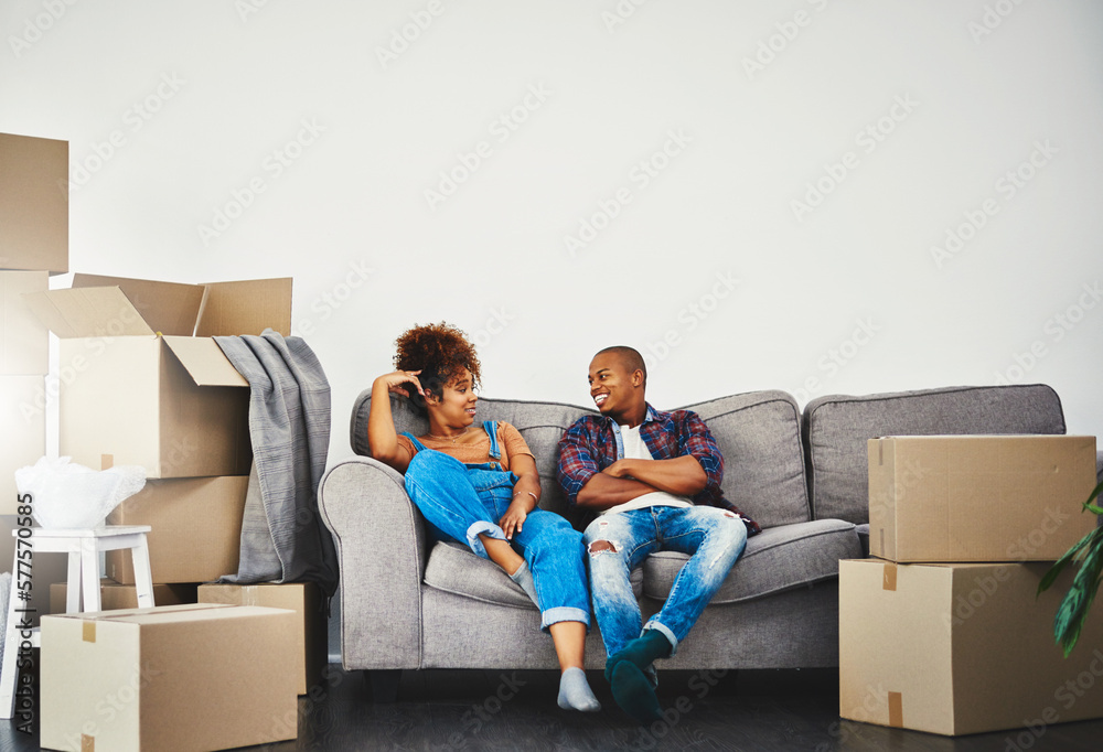 The beginning of conversations on the couch. Shot of an attractive young couple moving house. The beginning of conversations on the couch. Shot of an attractive young couple moving house.