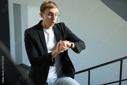 Принти на полотні Emotional young man checking time in office. Being late