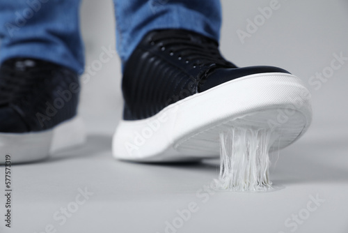 Man stepping into chewing gum on light grey background, closeup