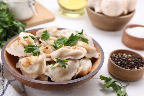 Delicious dumplings (varenyky) with potatoes, onion and parsley served on white wooden table