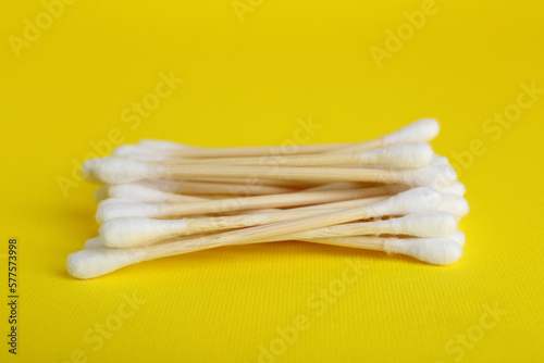 Wooden cotton buds on yellow background  closeup