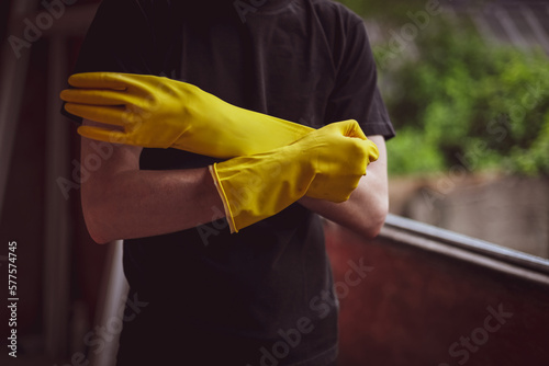 Caucasian male builder wears yellow gloves.