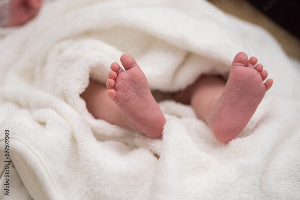 tiny baby legs of a newborn wrapped in a blanket. Close up. tiny baby legs of a newborn wrapped in a blanket. Close up.