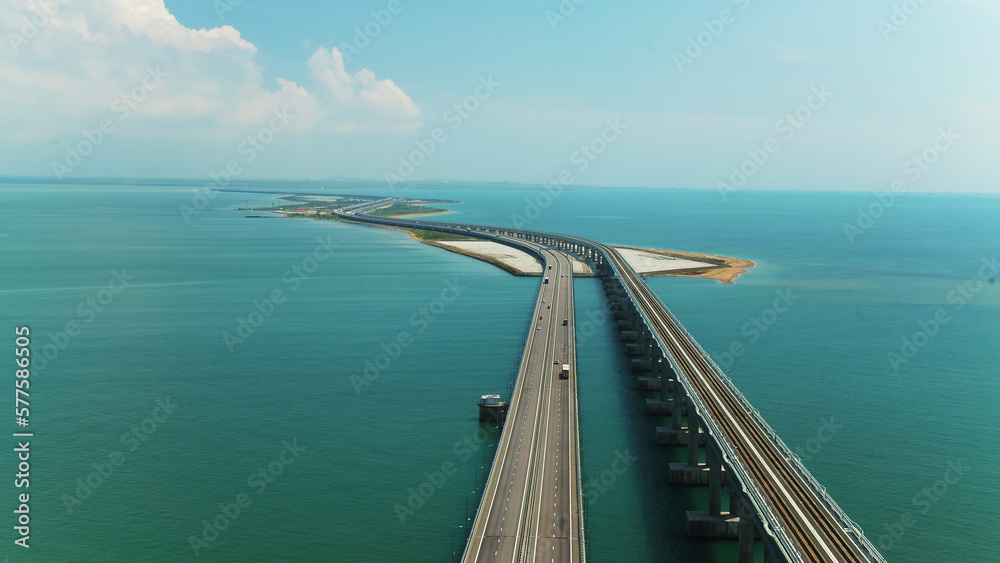 Top view of beautiful bridge over blue sea. Shot. Long highway with bridge over blue water. Bridge across strait between islands with beautiful seascape on sunny day