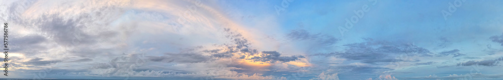 The blue sky is covered with soft blue and soft yellow clouds in sunset light.