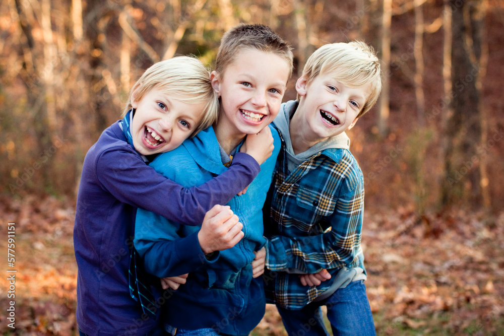 Fototapeta premium Three elementary aged boys laughing and smiling at the camera