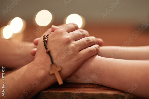 Overcoming anything with good friends and good faith. Cropped shot of two people holding hands and praying together.