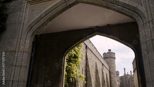 Wide gate to the ancient stone fortress. Action. Beautiful old stone high walls on a cloudy sky background. photo