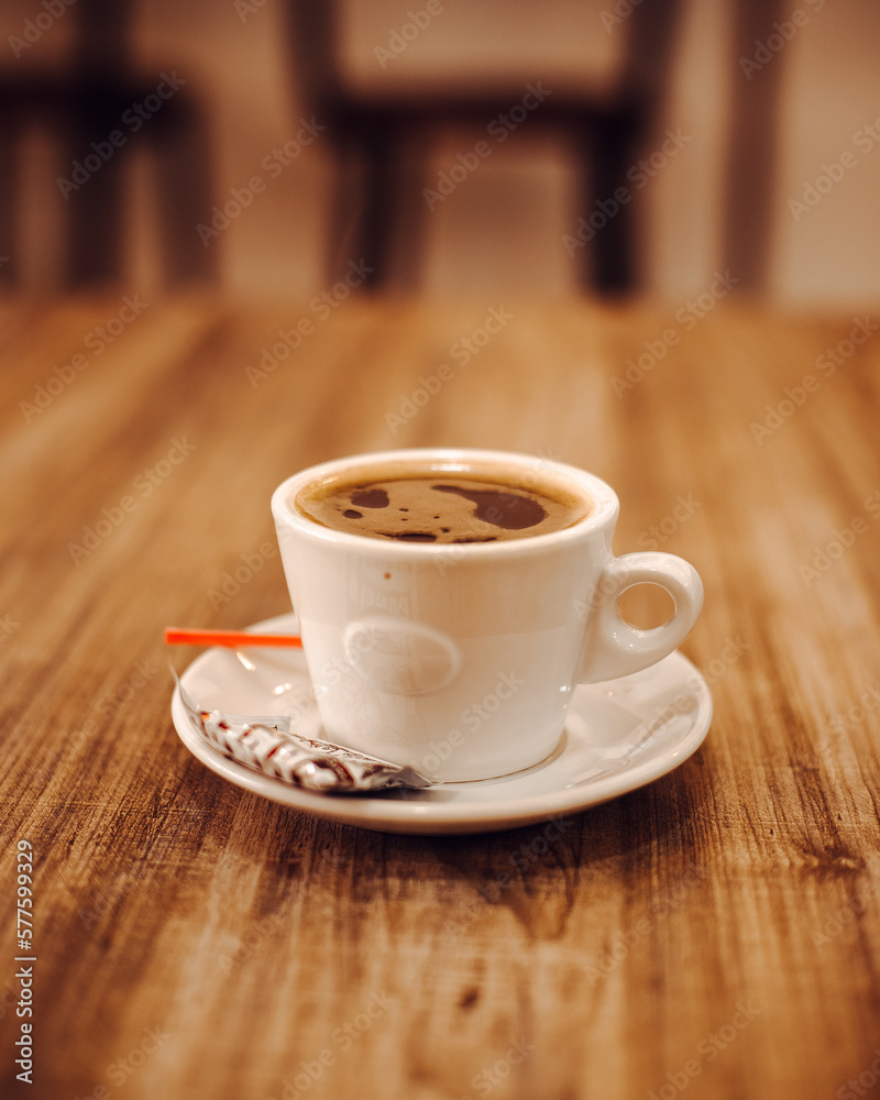Taza de cafe sobre mesa de madera con fondo claro