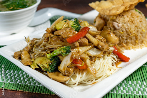 Stir-fried noodles with chicken and vegetables with chaufa rice. Wantan soup. Peruvian Chinese food. Chifa photo