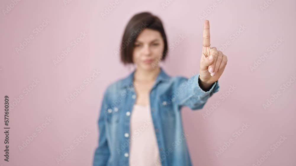 Young caucasian woman saying no with finger over isolated pink background Young caucasian woman saying no with finger over isolated pink background