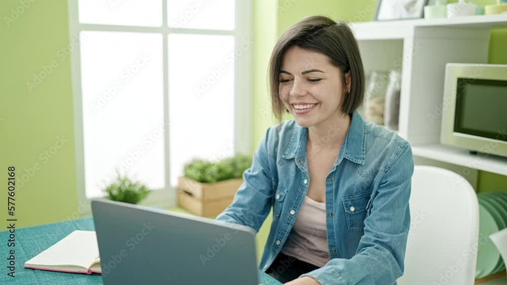 Young caucasian woman using laptop sitting on the table at home Young caucasian woman using laptop sitting on the table at home