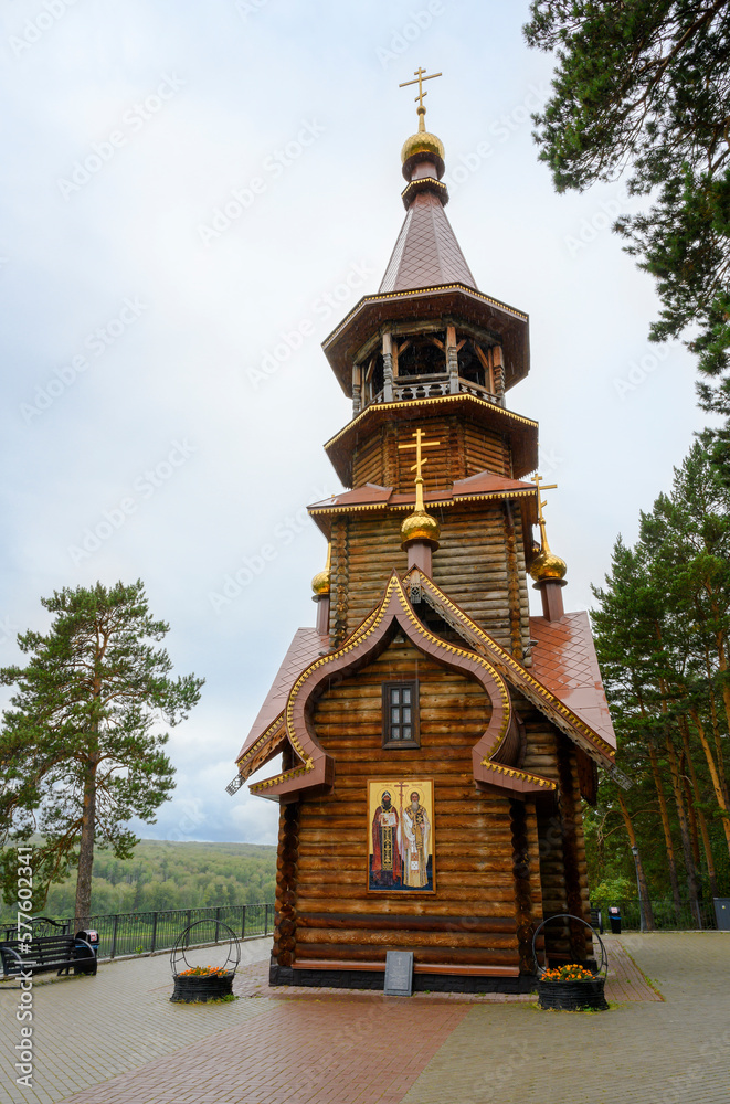 A wooden Christian Orthodox Сhurch with the text of a prayer on a stone tablet in Siberia, Russia, under a rainy sky A wooden Christian Orthodox Сhurch with the text of a prayer on a stone tablet in Siberia, Russia, under a rainy sky