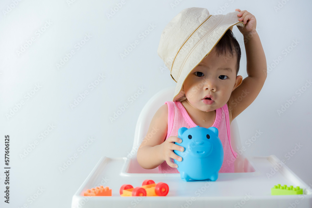 Baby boy inserting a coin into a piggybank on white background - financial concept Baby boy inserting a coin into a piggybank on white background - financial concept