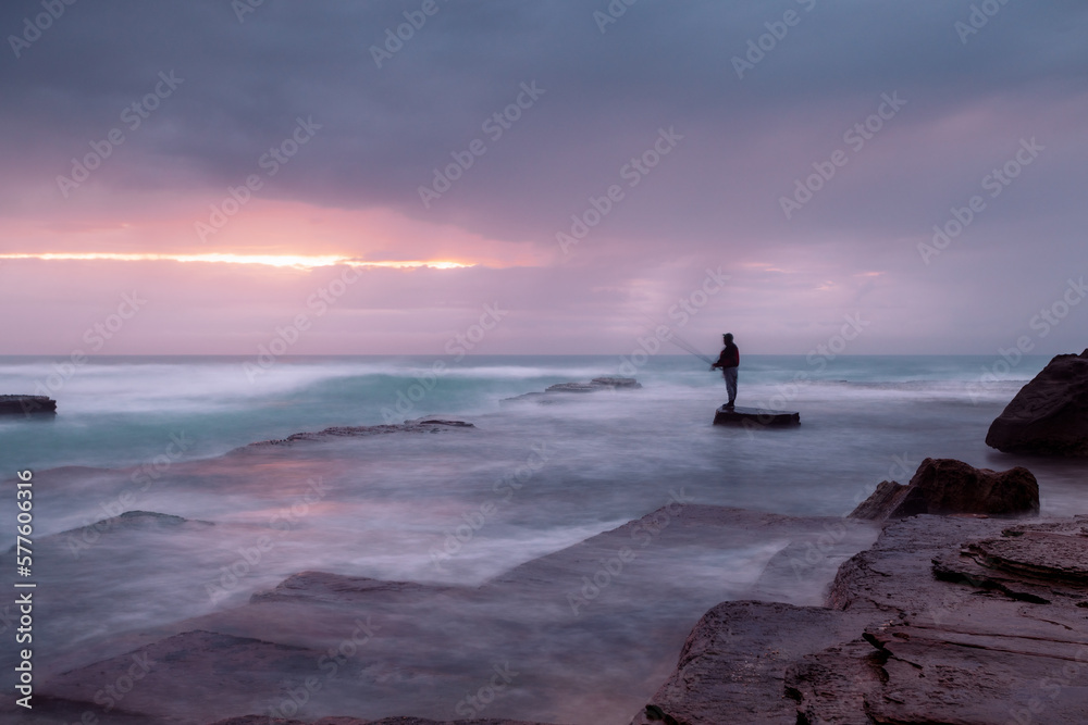 Stormy coast with a glimpse of sunrise through clouds