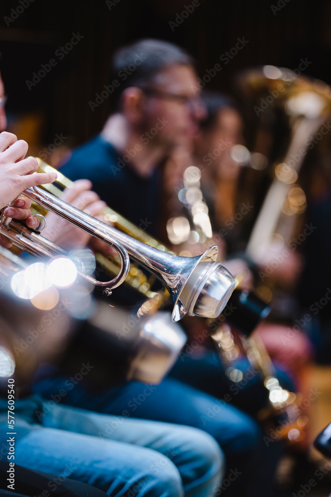 Obraz premium A musician playing a trumpet with a damaged mute in a trumpet section of an orchestra rehearsal