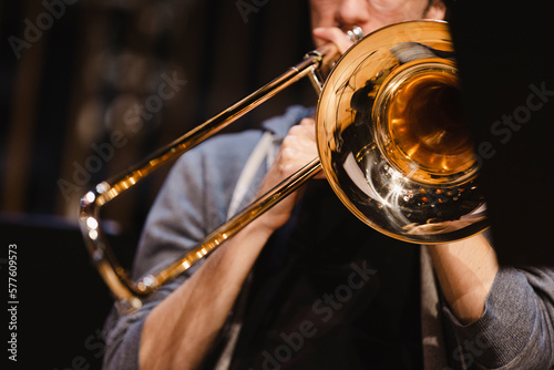 A musician playing a trombone during a casual wind ensemble rehearsal just before the concert photo