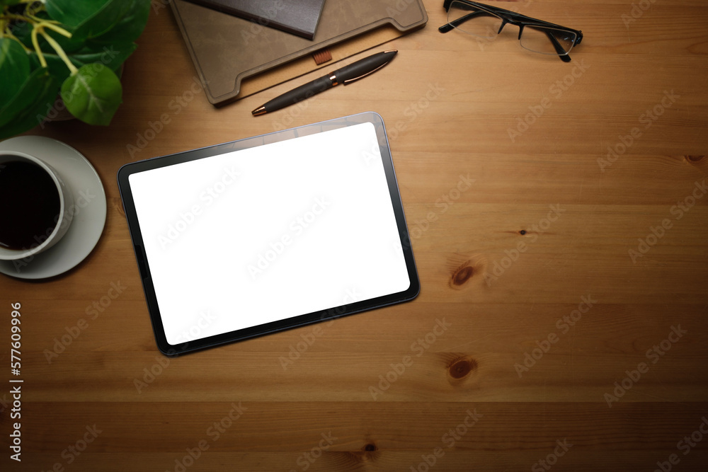 Above view of digital tablet with blank screen, coffee cup and eyeglasses on wooden table. Above view of digital tablet with blank screen, coffee cup and eyeglasses on wooden table.